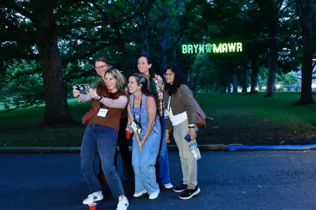Alums taking a selfie in front of a Bryn Mawr sign