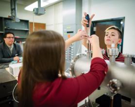 Physics professor and students working in a lab.