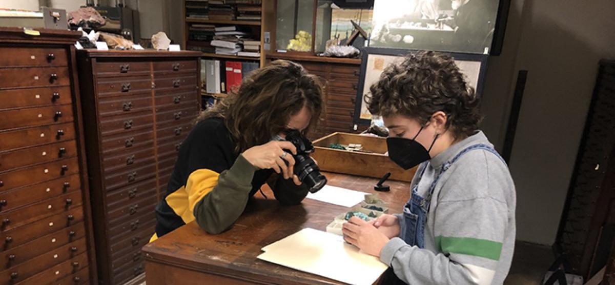 Artist and student look at empty boxes that remain from the uranium once stored in the collection.