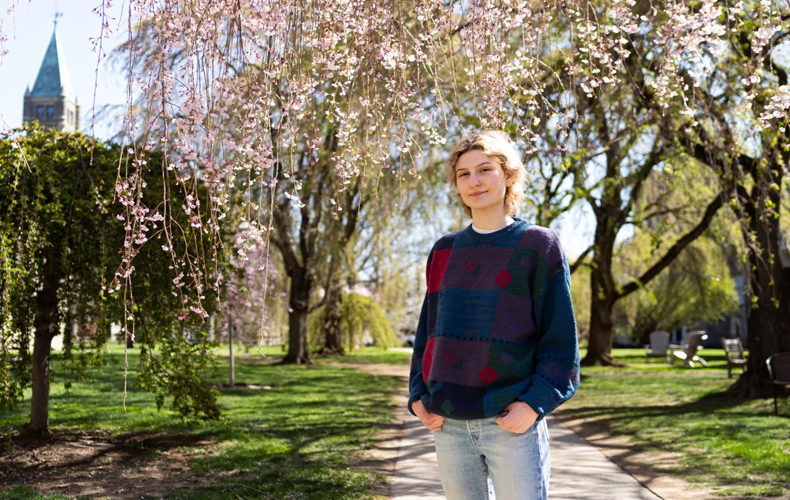 Charli Parsons '25 under the cherry blossom trees with Taylor Hall in the background