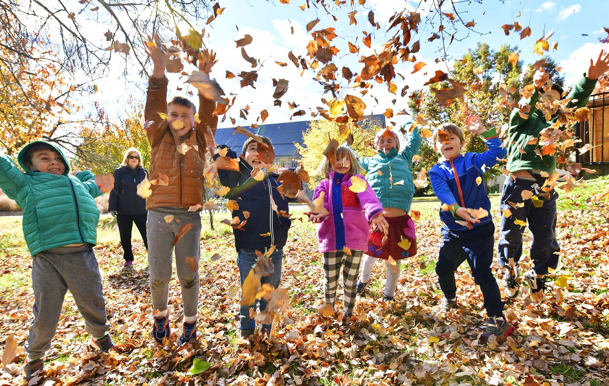 Young children throwing leaves in the air