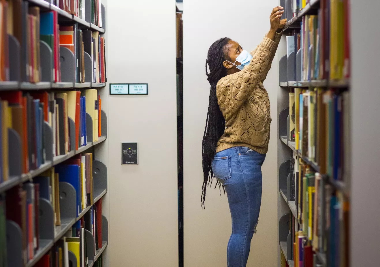 student in library stacks