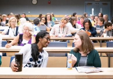 Volunteers in a classroom setting talking with each other