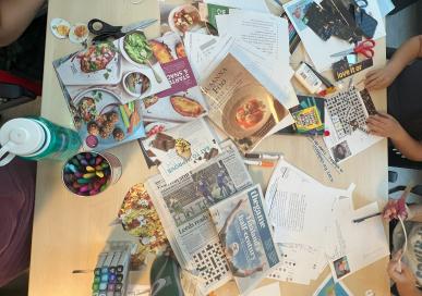 Table full of collage materials (magazine cutouts, pens, glue, etc.)