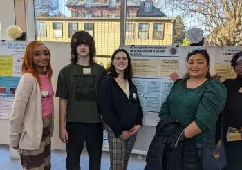 Students with community mentor at the Praxis poster session