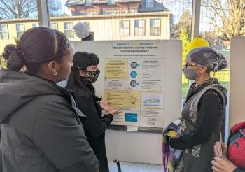 Students with community mentor at the Praxis poster session