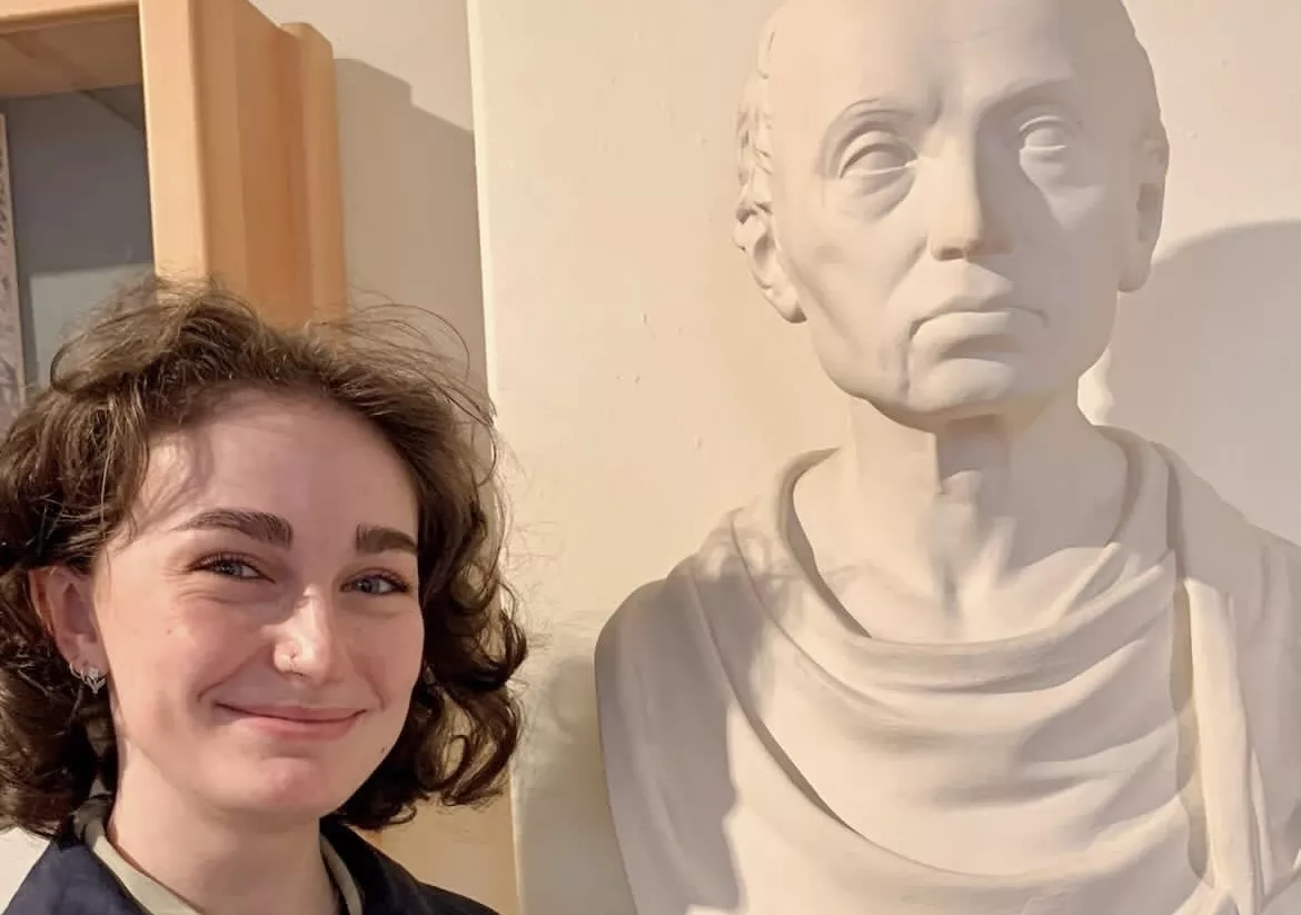 Emily Shein posing with a bust of Immanuel Kant