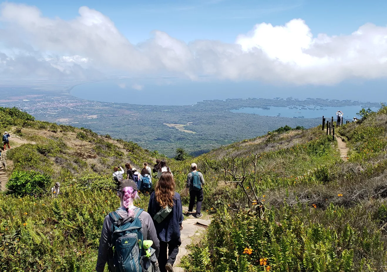 Students and faculty hiking toward a viewpoint on Volcan Momacho with a view of the city of Granada, Lago Cocibolca, and Las Isletas in the distance.