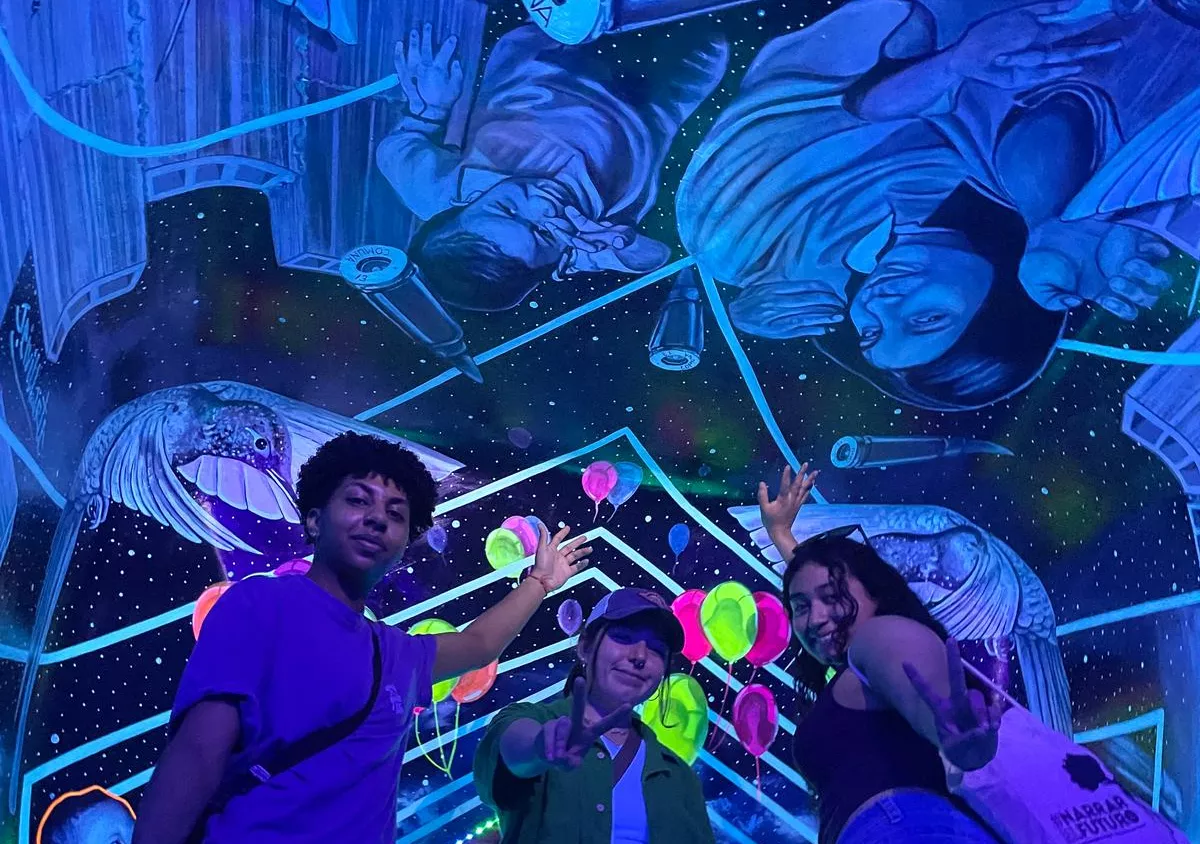 three students at an exhibition