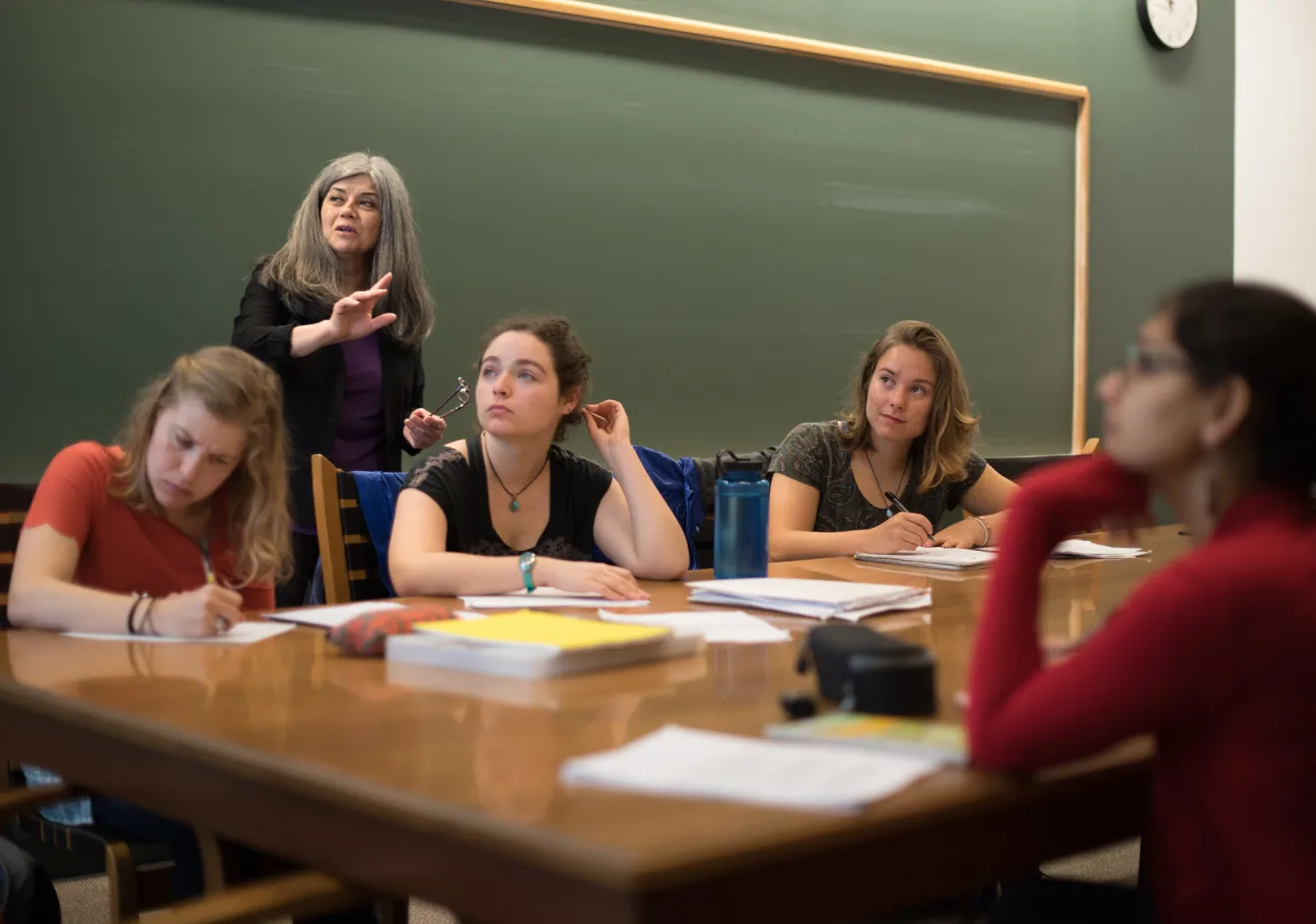 faculty and students in classroom with chalkboard behind them