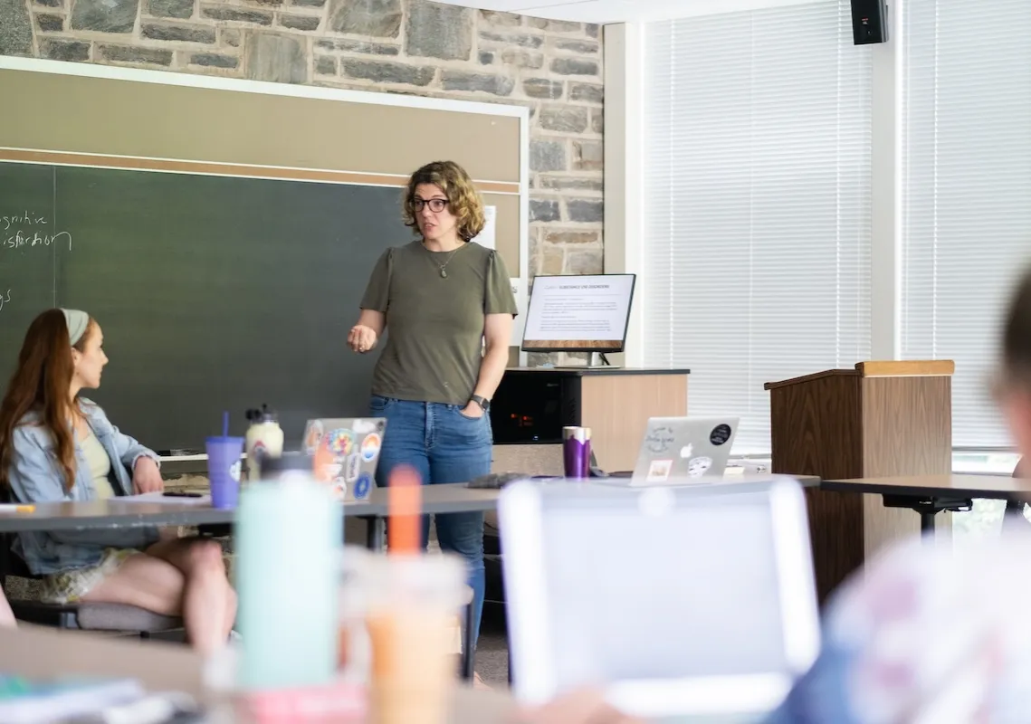 faculty and students in classroom with chalkboard behind them