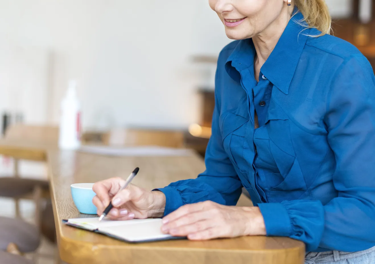 side-view-older-woman-with-pen-notebook-working