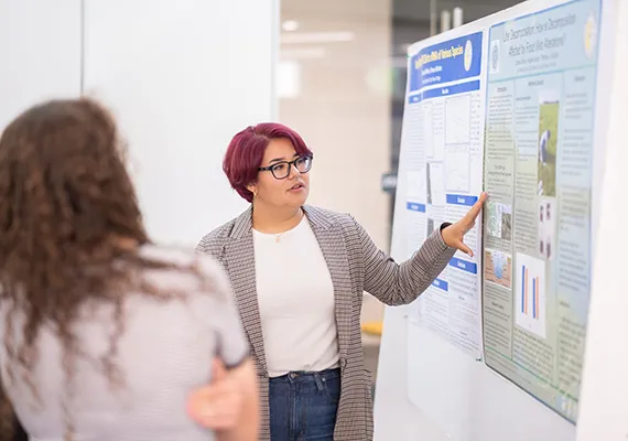 Jocelyn Bravo explains her research at the Summer Science poster session.