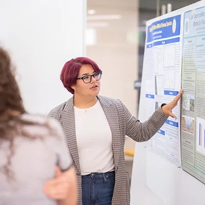 Jocelyn Bravo explains her research at the Summer Science poster session.