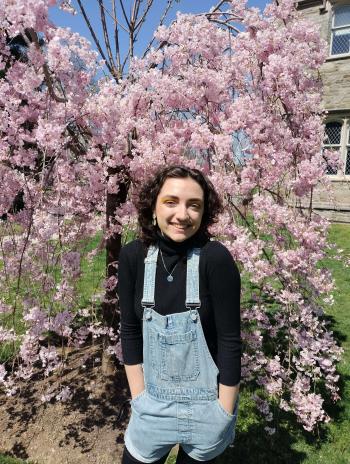 Arlowe Willingham in front of a cherry blossom tree. 