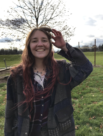 Headshot of Cate Elam '25 standing in front of a field