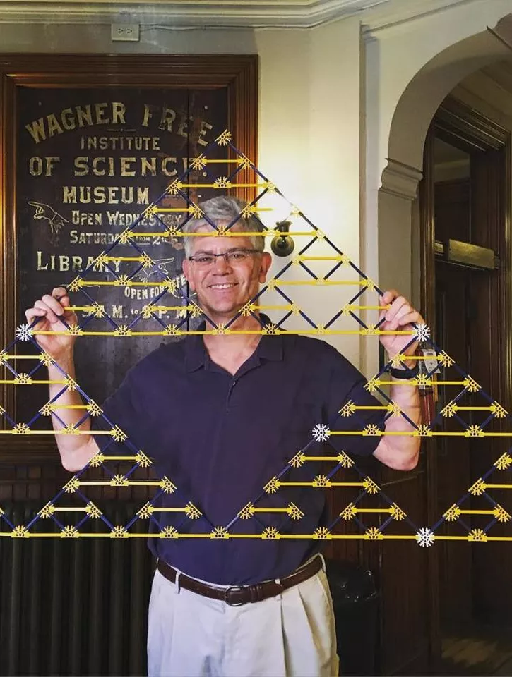 Professor of Mathematics Victor Donnay holding a triangle built of K'Nex pieces.