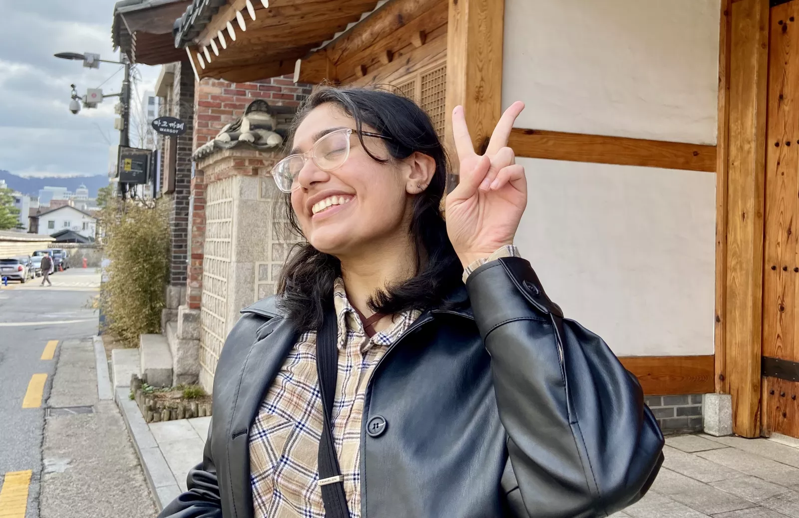 Aanandi Murlidharan posing with a peace sign outside of the Seoul Fortress