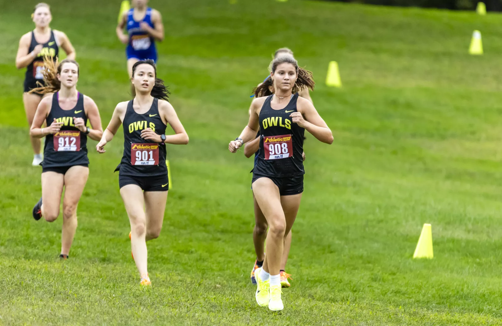 Students running on a grass field. 