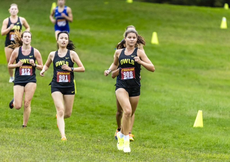 Students running on a grass field. 