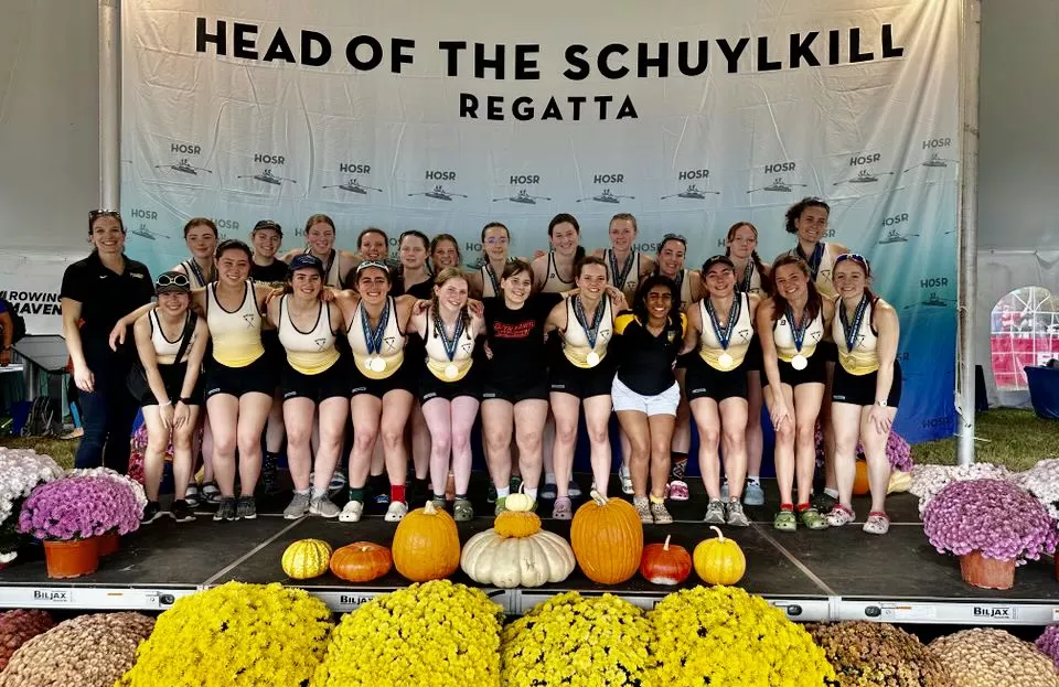 Group photo of the Rowing team in front of the "Head of The Schuylkill" Photo Banner
