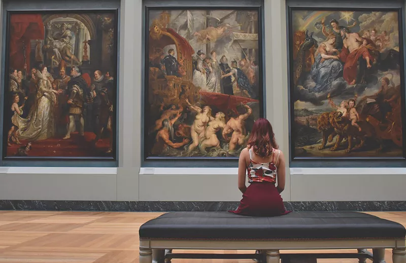 Woman looking at paintings in museum