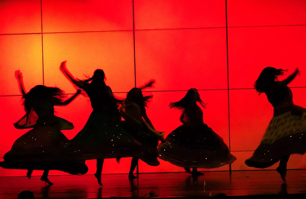 Red Background with silhouettes of student dancers