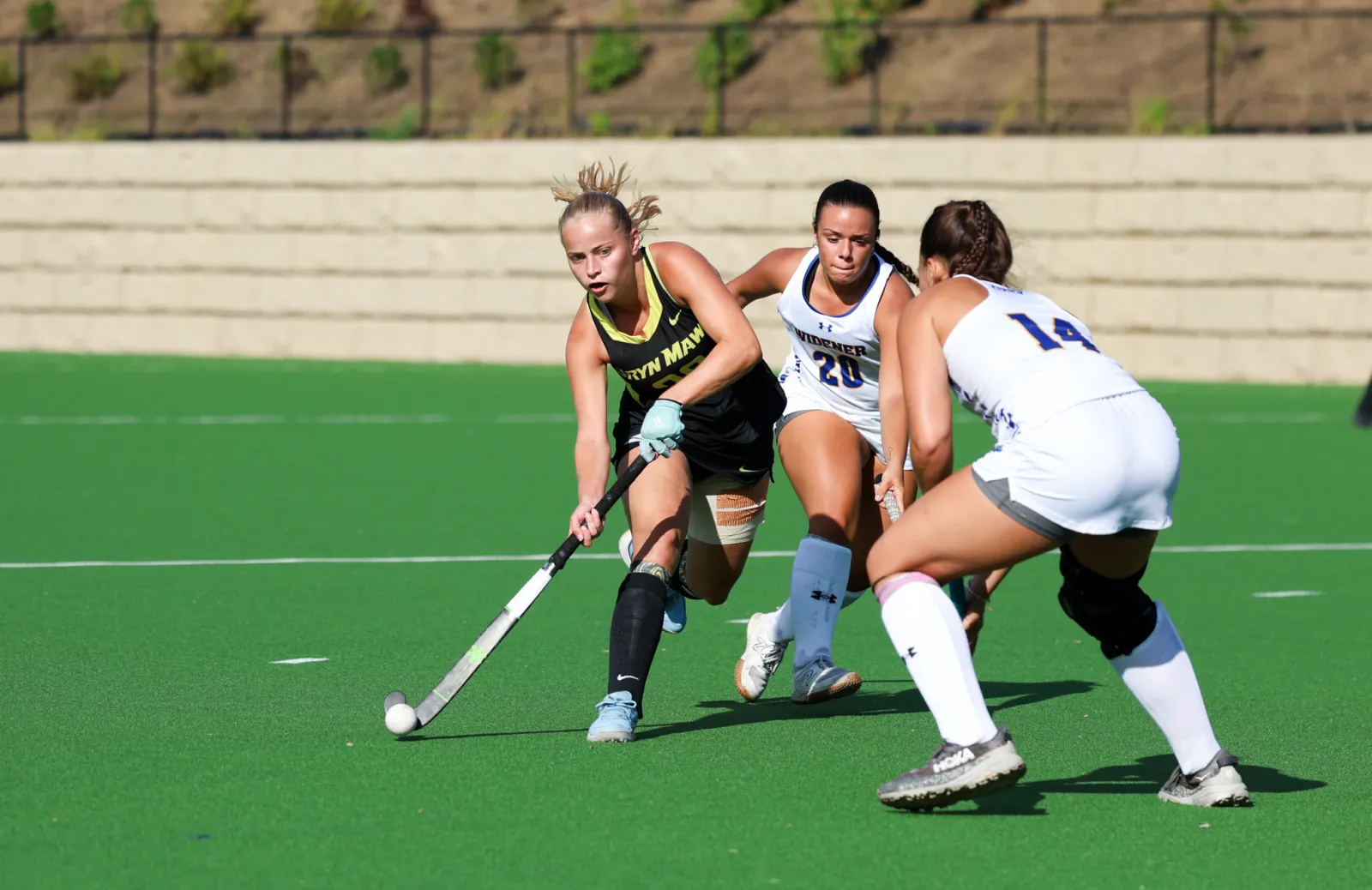 Three field hockey players on the field