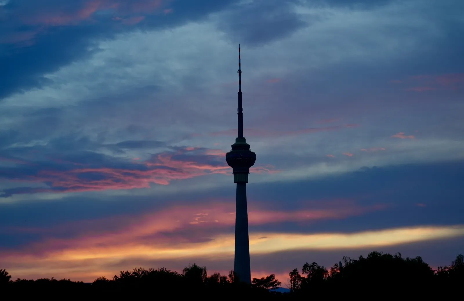 a CCTV tower in Beijing contrasting with a sunset