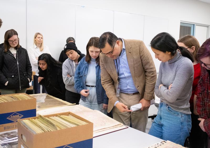 Students in 'The Philadelphia Mosaic' view material from Temple University's Urban Archives with Librarian 