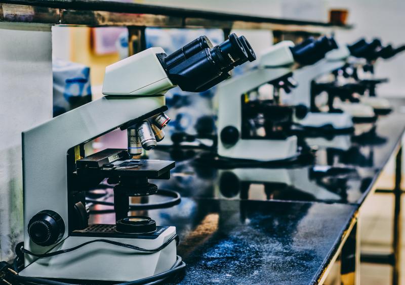 white microscope on top of black table photo