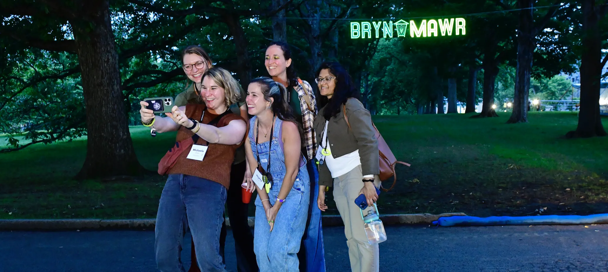 Alums taking a selfie in front of a Bryn Mawr sign