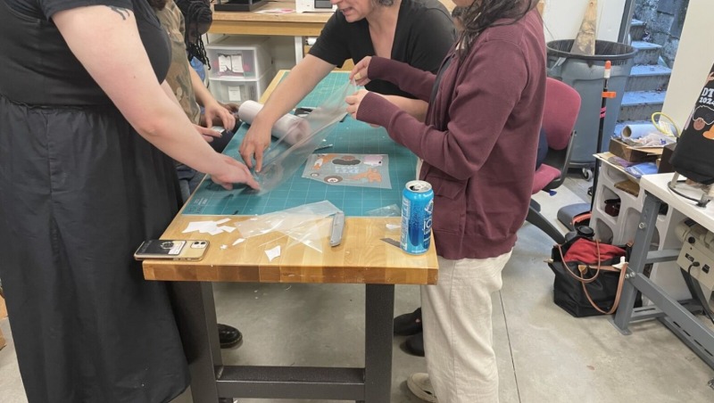 The Digital Technology Interns work with Bronwen Densmore, Makerspace Coordinator, on an introductory project for the program, creating a group tote bag 