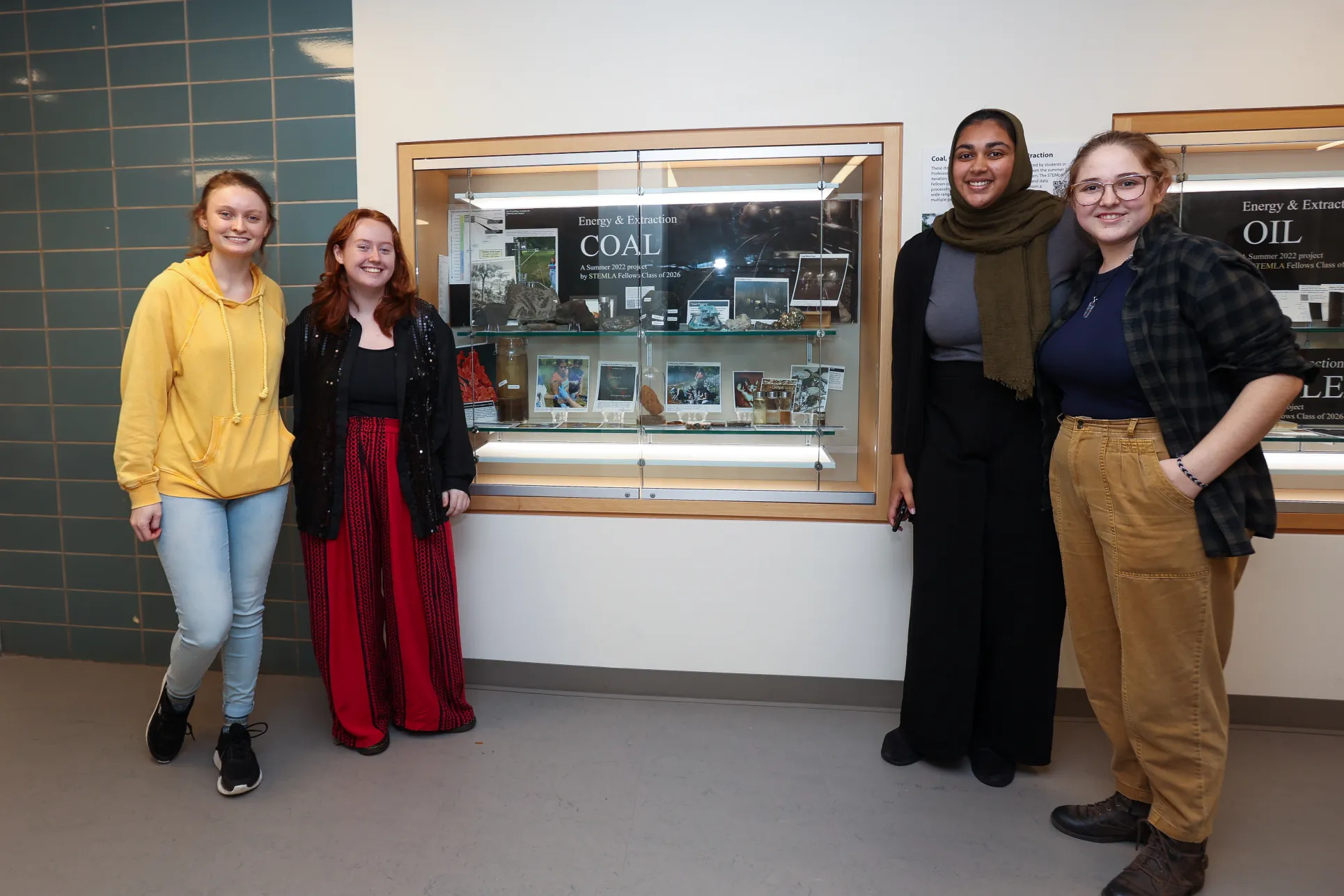 STEMLA Fellows post in front of display case