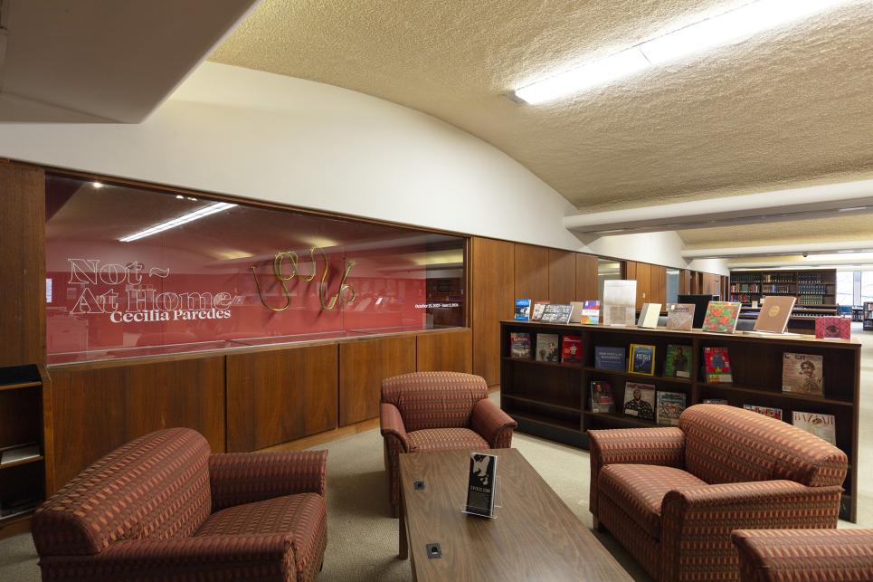 Gallery entrance with seating and reading materials, Not At Home exhibition