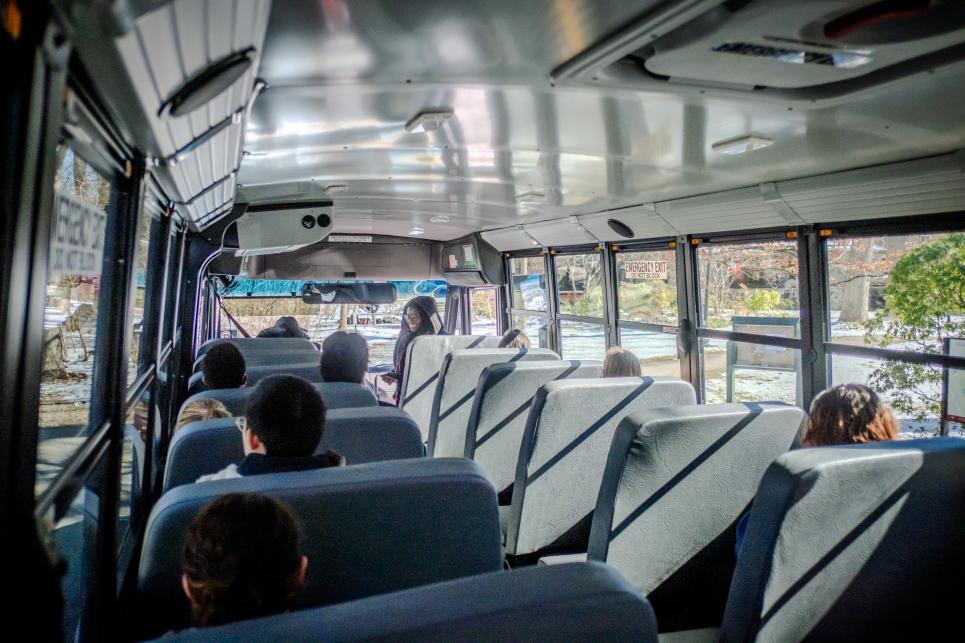 Students board the electric bus.