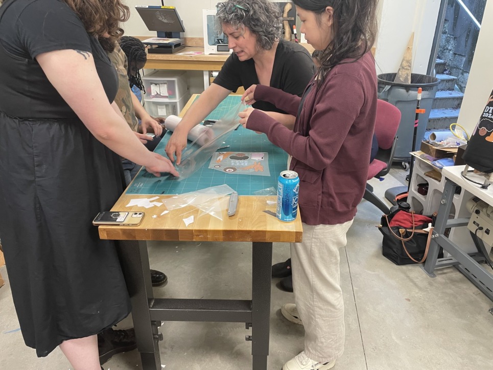 The Digital Technology Interns work with Bronwen Densmore, Makerspace Coordinator, on an introductory project for the program, creating a group tote bag 