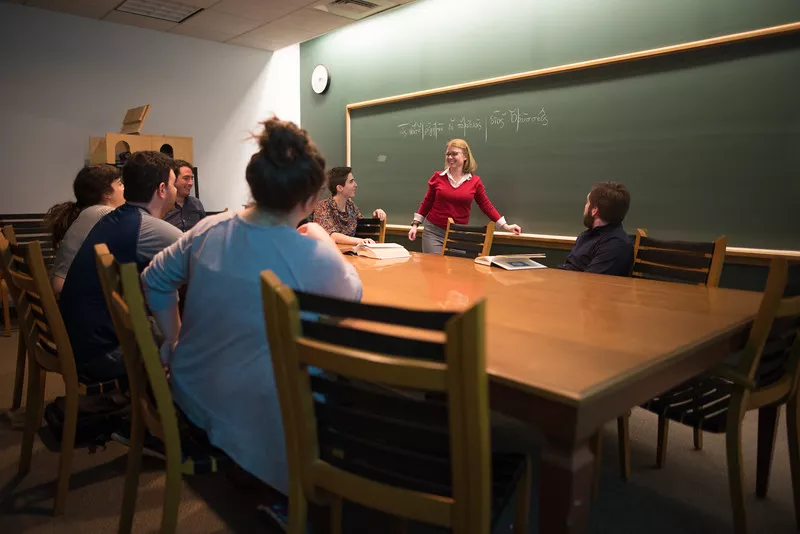 Graduate student leads discussion with peers.