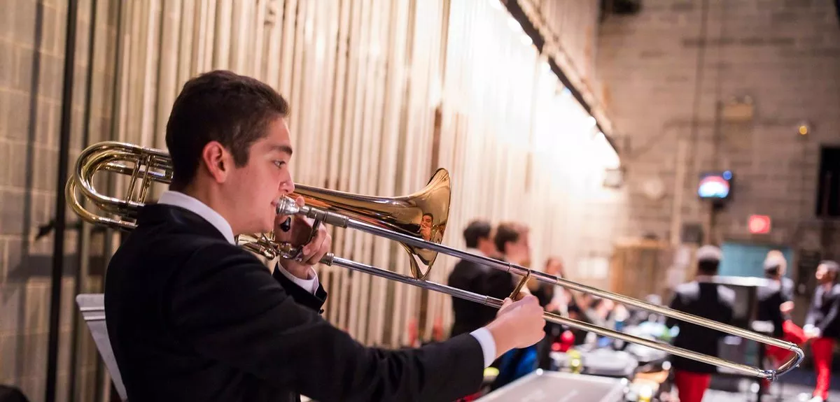 Student in black sweater plays trombone