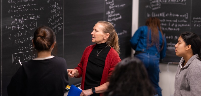 professor-lisa-traynor-teaching-students-math-at-chalkboard