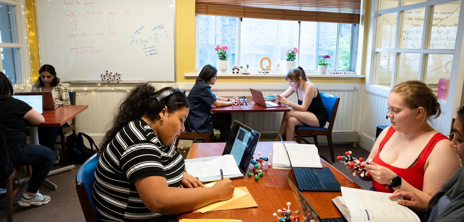 Six students at tables in the Quantitative Center
