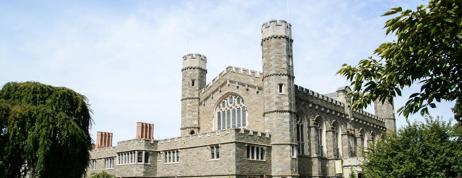Large stone building with students walking across lawn
