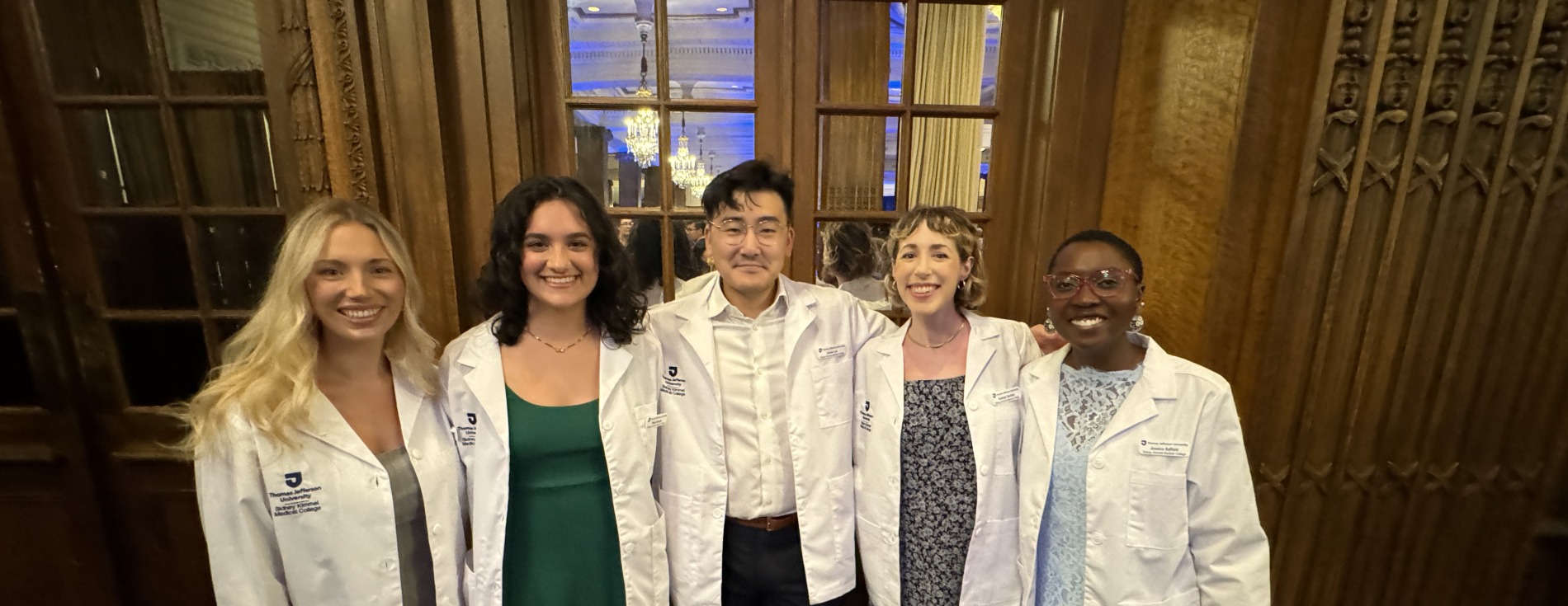 Group of smiling students wearing med student white coats