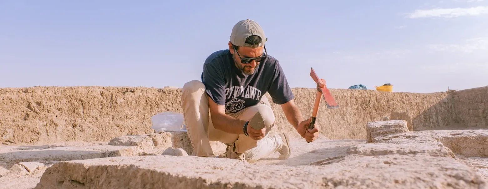 Rocco wearing a Bryn Mawr shirt at a dig site