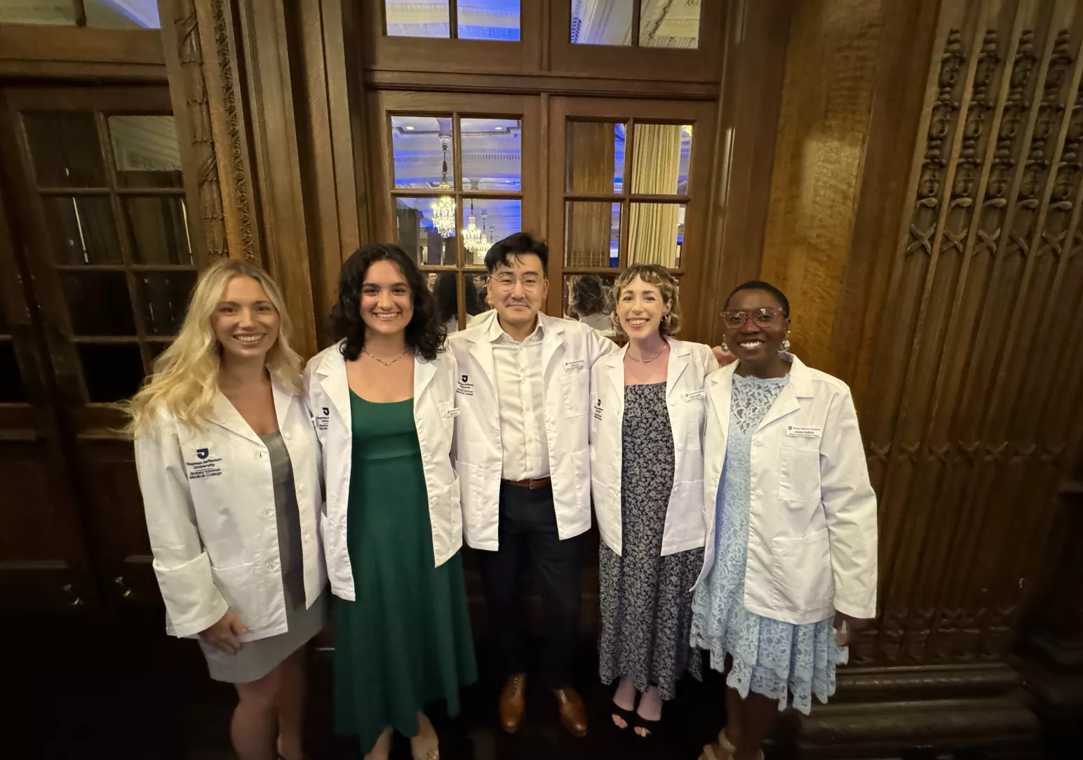 Group of smiling students wearing med student white coats