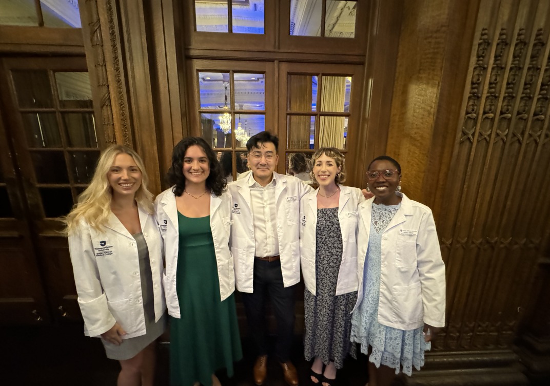 Group of smiling students wearing med student white coats