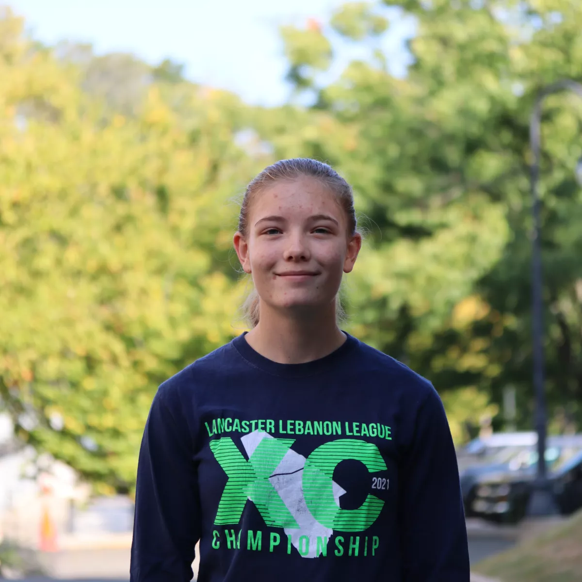 Claire Thomas in black long sleeved shirt with green writing. 