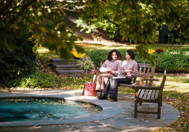 Two students sitting on a bench in Taft Garden