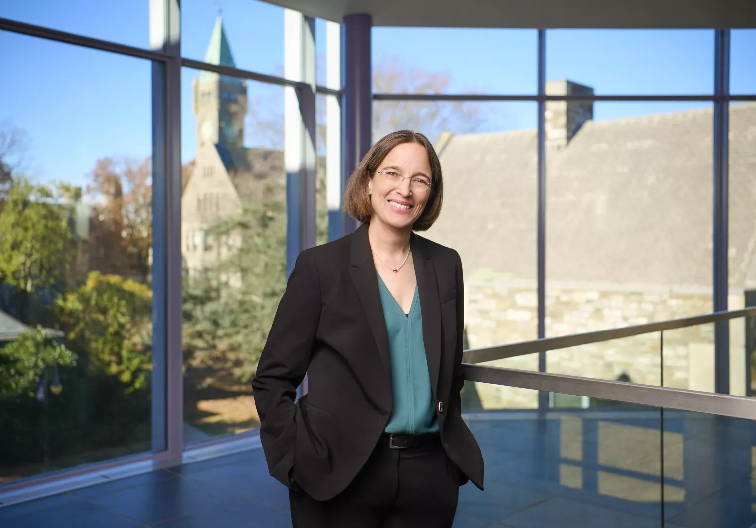 Woman in black suit in front of large window