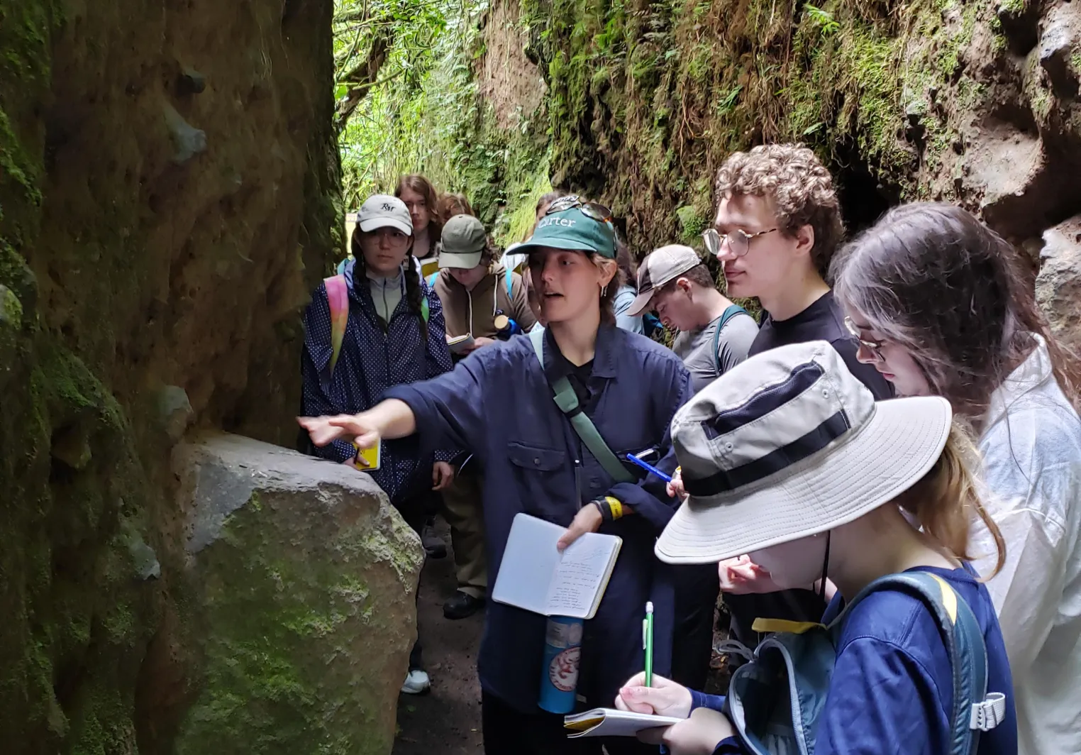 Students studying rocks in a tunnel formed through a volcanic mudslide near the summit of Volcan Mombacho, Nicaragua.
